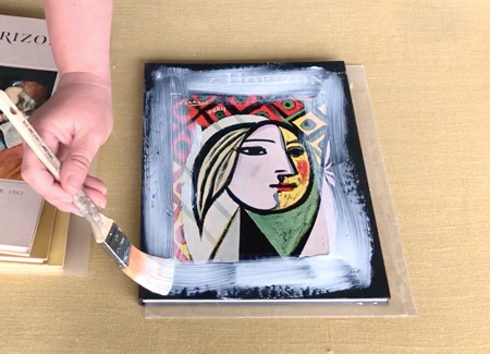 Painting glue onto the cover of a book